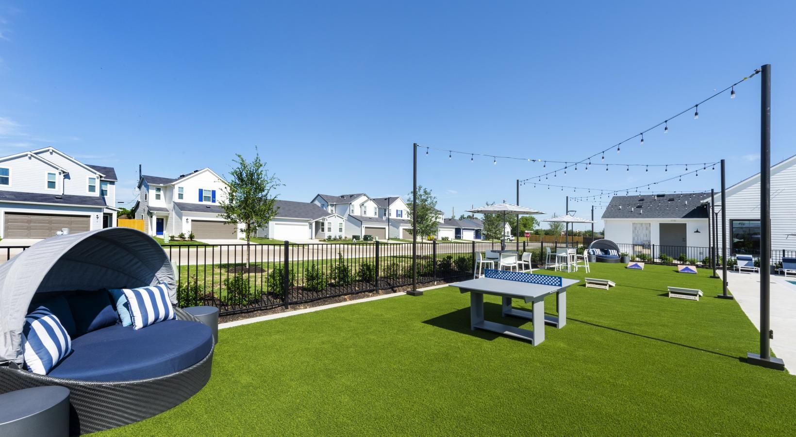 Settle into comfort at Inspire Missouri City a backyard with a table and chairs