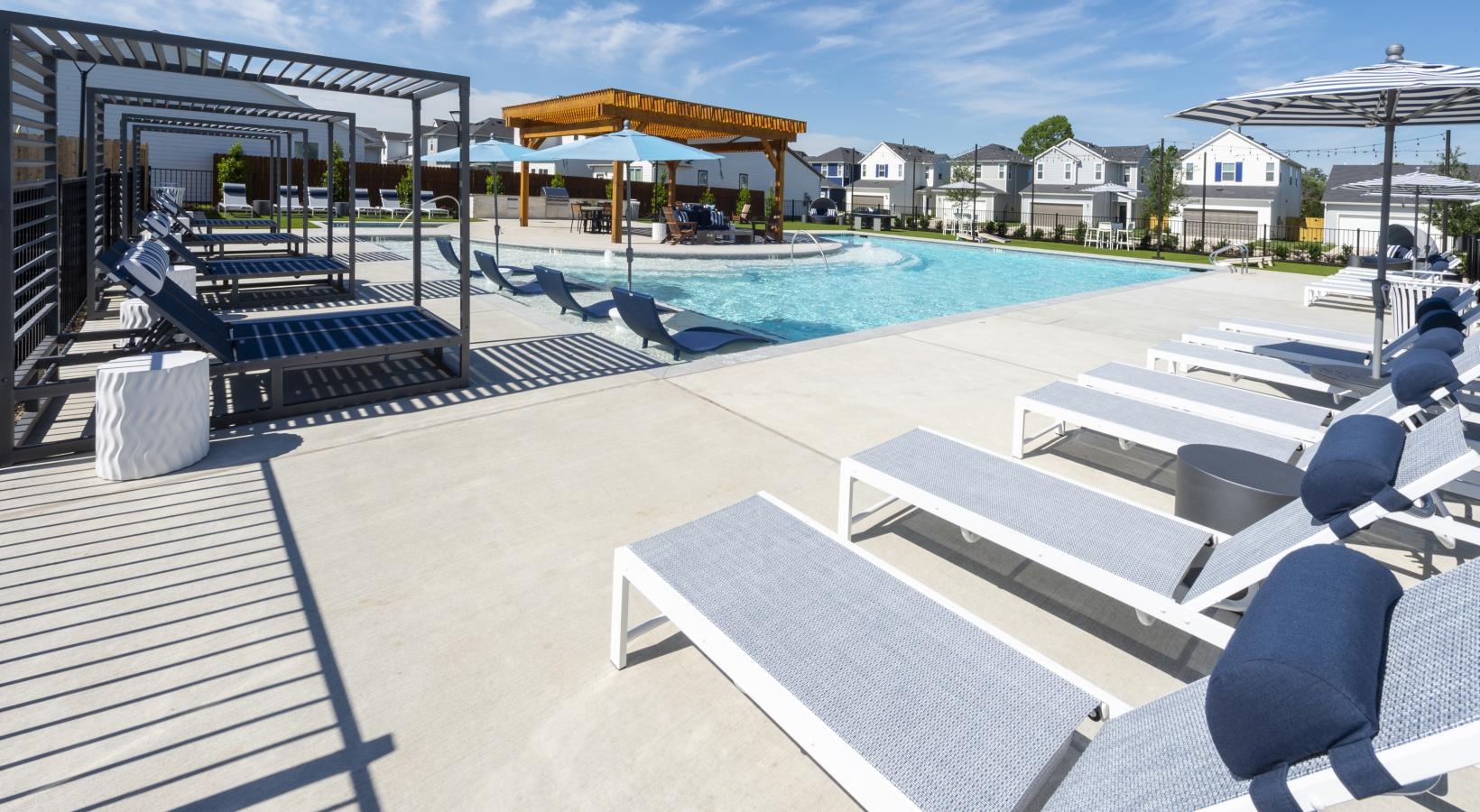 Relax and unwind poolside a pool with lounge chairs around it