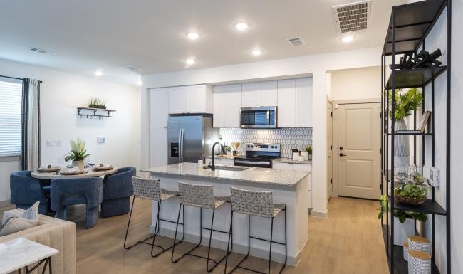 Spacious kitchens with thoughtful details a kitchen with a bar and chairs